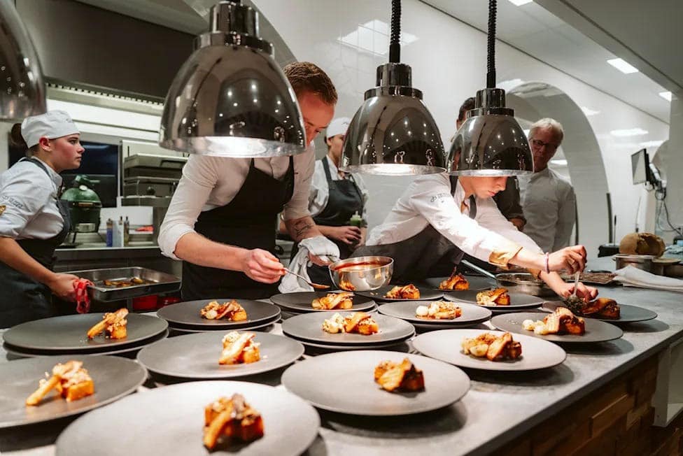 Kitchen team plating dishes during service